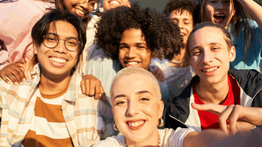 Smiling, diverse group of teenagers taking a selfie, representing inclusive youth ministry and affirming spaces for LGBTQ+ youth.