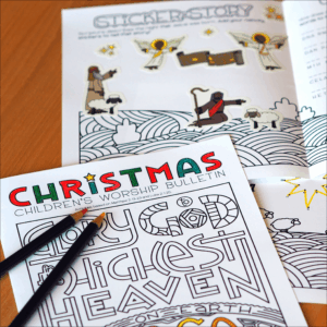 A children’s Christmas worship bulletin and sticker story page featuring line-art illustrations, partially colored sections, and colored pencils on top.
