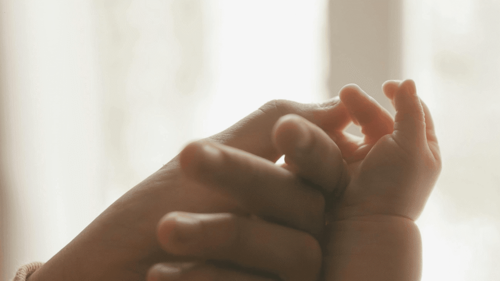 Close-up of two hands gently holding, symbolizing care, connection, and spiritual reflection.
